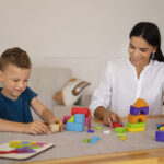 A kid using colorful educational blocks during a therapy session