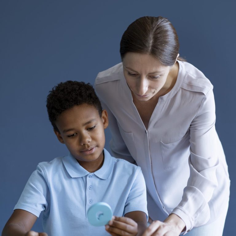Speech therapist assisting a young boy with colorful educational therapy tools.